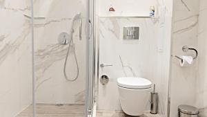a white bathroom with a shower and a toilet at Lux 2 Central Apartment with Garage in Plovdiv +23 photos