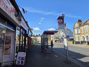 a person standing at a bus stop on a street at Brigstock3 in Thornton Heath +2 photos