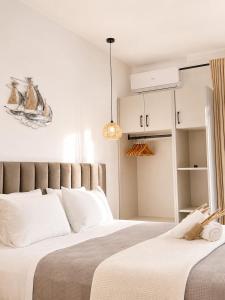 a bedroom with a large bed with white pillows at Nefonas Guest House in Skiathos