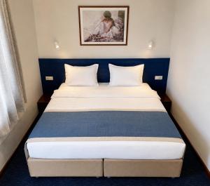 a bedroom with a large bed with a blue headboard at Cruise Hotel in Tbilisi City