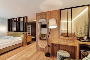 a bedroom with a bed and a desk with a lamp at Hotel Erica in Tesero +219 photos