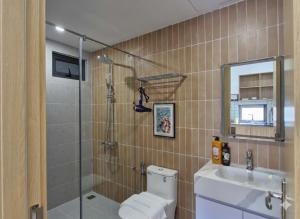 a bathroom with a shower and a toilet and a sink at Seaflow Staycation in Danang +80 photos