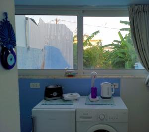a washing machine in a room with a window at Valantas Garden Suite in Lartos