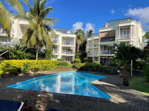 a swimming pool in front of two apartment buildings at Résidence îlot in Grand-Baie