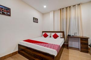a bedroom with a bed with red pillows on it at Hotel O Axom Inn in Barpeta