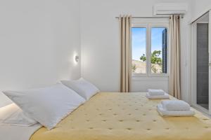 a bedroom with a bed with two towels on it at Kamelia Hotel in Spetses