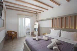 a bedroom with a bed with towels on it at Alexander Studios & Suites - Adults Only in Faliraki +111 photos