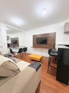 a living room with a couch and a flat screen tv at Apê aconchegante e climatizado - Villa Kennidy in Caruaru