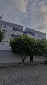 a building with a tree in front of it at Intermares perto de tudo com 3 quartos in Cabedelo