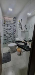 a bathroom with a toilet and a sink and a mirror at Intermares perto de tudo com 3 quartos in Cabedelo