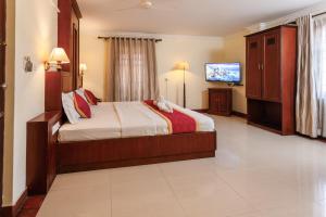 a bedroom with a bed and a flat screen tv at Padipura Residency in Alleppey