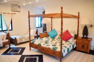 a bedroom with a canopy bed with colorful pillows at M Villa’s Farm Resort in Romblon +106 photos