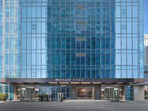 a large glass office building with a lot of windows at Mercure Hefei City Hall Square in Hefei