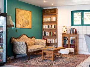 a living room with a couch and a table at greet Hôtel Montbéliard in Montbéliard
