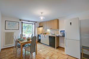 a kitchen with a table and a white refrigerator at Ca Cornocc with Private Terrace in Gordola - Happy Rentals in Gordola