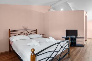 a bedroom with a bed and a television at Villa Kontesa in Lovran