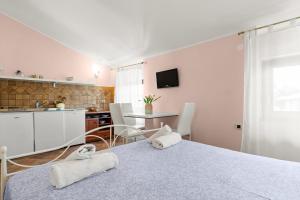 a room with a bed and a kitchen with a table at Villa Kontesa in Lovran
