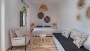 a bedroom with a bed and a couch and a chair at Villa NoYa in Oualidia