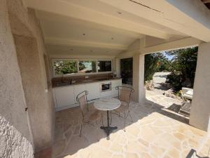 a kitchen with a table and chairs on a patio at La Bergerie B&B in Vence