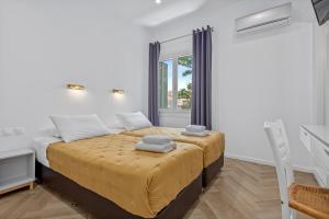 a bedroom with a bed with yellow sheets and a window at Kamelia Hotel in Spetses +34 photos