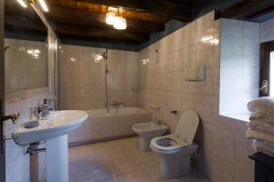 a bathroom with a sink and a toilet and a bath tub at Dimora Dory Luxury in Nave +9 photos