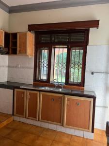 a kitchen with a sink and a window at Happy Fish Villa in Entebbe