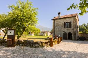 an old stone building with a tree in front of it at Dimora Dory Luxury in Nave