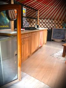 a kitchen with a counter and a wooden floor at Le Ptit Mas Yourte ou Logicube in Salernes +30 photos