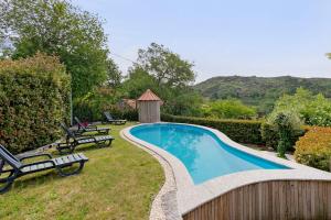 a swimming pool in a yard with two lawn chairs at Casa do Moinho in Aboim