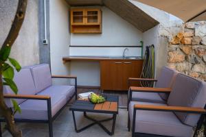 a patio with two chairs and a table and a kitchen at Castello in Mali Lošinj
