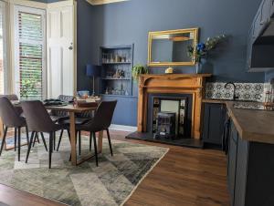 a dining room with a table and a fireplace at Mulberry Lodge -- a luxury cottage on the West Highland Way in Drymen