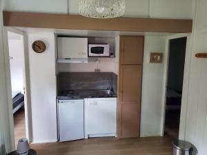 a small kitchen with a stove and a microwave at Chalets du Causse 2 in Gelle