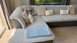 a teddy bear sitting on a couch with pillows at Villa 't Zonneroosje in Nieuwpoort
