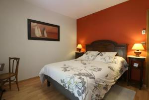 a bedroom with a bed and two tables and two lamps at Les Anthémis in Gujan-Mestras