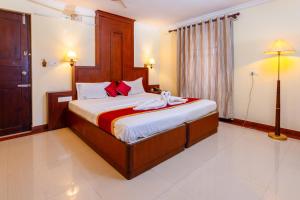 a bedroom with a large bed with two towels on it at Padipura Residency in Alleppey