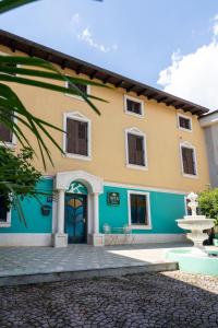 a yellow and blue house with a fountain at Villa Kontesa in Lovran