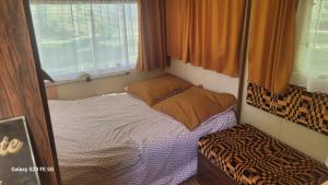 a small room with a bed and a window at CHEZ JOSETTE caravane Camping le sorbier Montignac Lascaux in Montignac +15 photos