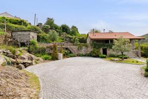 a driveway in front of a house with a building at Casa do Moinho in Aboim