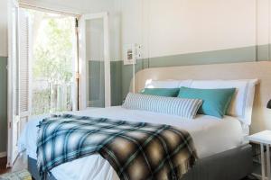 a bedroom with a bed with blue and green stripes at Artful Hideaway with Pool & Fireplace in Riebeek-Kasteel