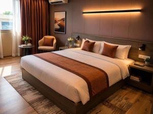 a bedroom with a large bed and a chair at Click Hotels Lite Chakan in Pune