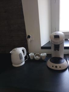 a kitchen counter with a coffee maker and measuring cups at Gîte les coquelicots côté jardin in Morbier