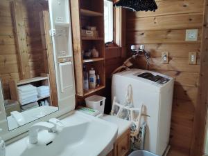 a bathroom with a sink and a washing machine at Siodomi Marinki shared wood lodge, pets allowed for a fee in Ōkuki +56 photos