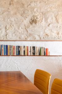 a table and two chairs and a shelf with books at Casa Yolanda in Bojar