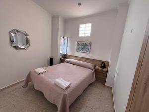 a bedroom with a bed with two towels on it at Hostal Gutierrez in Ceuta