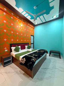 a bedroom with a bed with an orange wall at Keshav Vatika Palace - 800 meter Ram Mandir in Ayodhya