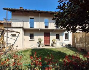 a house with a red door and a yard at Kiki's Langhe House in Castagnole Lanze