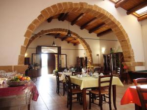 a dining room with a table and an archway at L'antico Trappeto Holiday Home in Noto