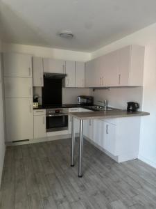 a kitchen with white cabinets and a wooden table at Lingen Stay 2 in Lingen
