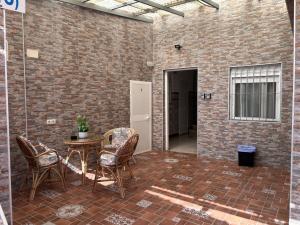 a patio with a table and chairs and a brick wall at Hostal Gutierrez in Ceuta