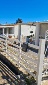a white fence in front of a house at I Venti di Vulcano in Vulcano